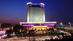 A modern hotel with a curved top, multiple floors, and a well-lit facade. - Cinese Hotel Dongguan (Dongguan)