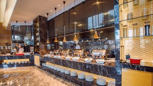 A modern kitchen with marble countertops, stainless steel appliances, and hanging pendant lights. - Cinese Hotel Dongguan (Dongguan)