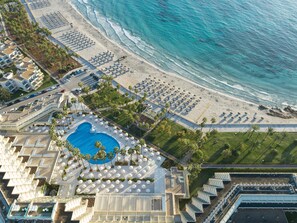 Ein Luftbild eines Resorts mit großem Pool, Strand und Ozean.