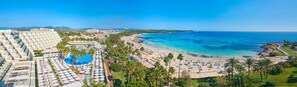 Ein Resort mit großem Pool, Strand und Blick auf den Ozean.