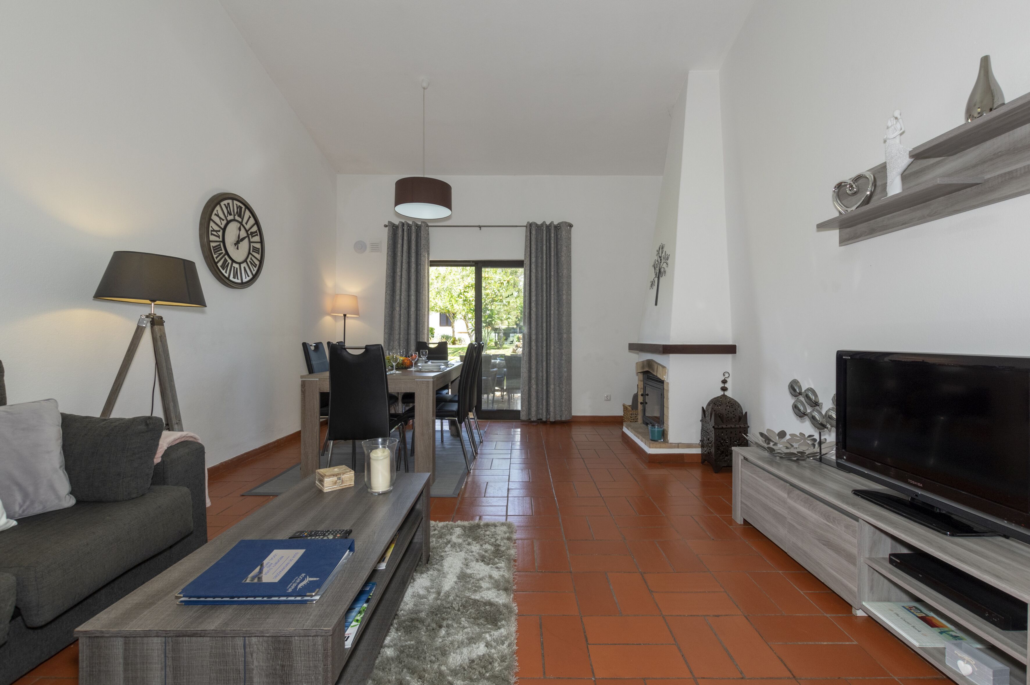 A living room with a sofa, coffee table, TV, and fireplace.