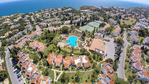 An aerial view of a residential area with houses, a swimming pool, and a tennis court. - Rocha Brava Village Resort (Lagoa)