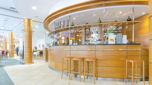 Un espace bar avec des tabourets, un comptoir avec des bouteilles et une enseigne sur laquelle on peut lire « SOBRY BAR ».