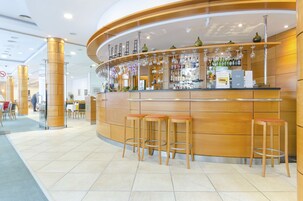 Uma área de bar com banquetas, um balcão com garrafas e uma placa com a inscrição 'SOBRY BAR'.