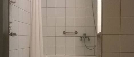 A bathroom with a shower, a toilet, and a sink.