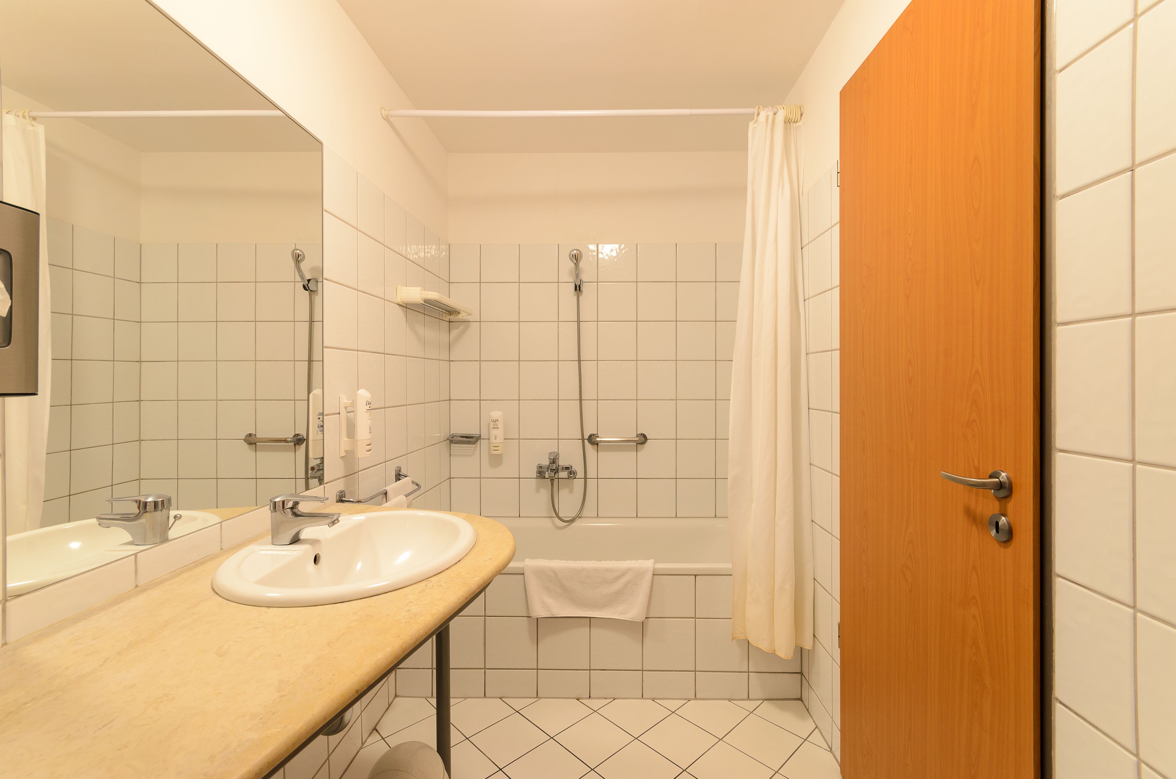 Un baño con dos lavamanos, una ducha y una puerta de madera.