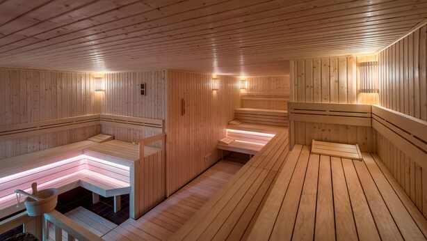 Uma sauna de madeira com bancos e bancos embutidos.