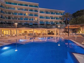 Una piscina techada, una piscina al aire libre, sombrillas