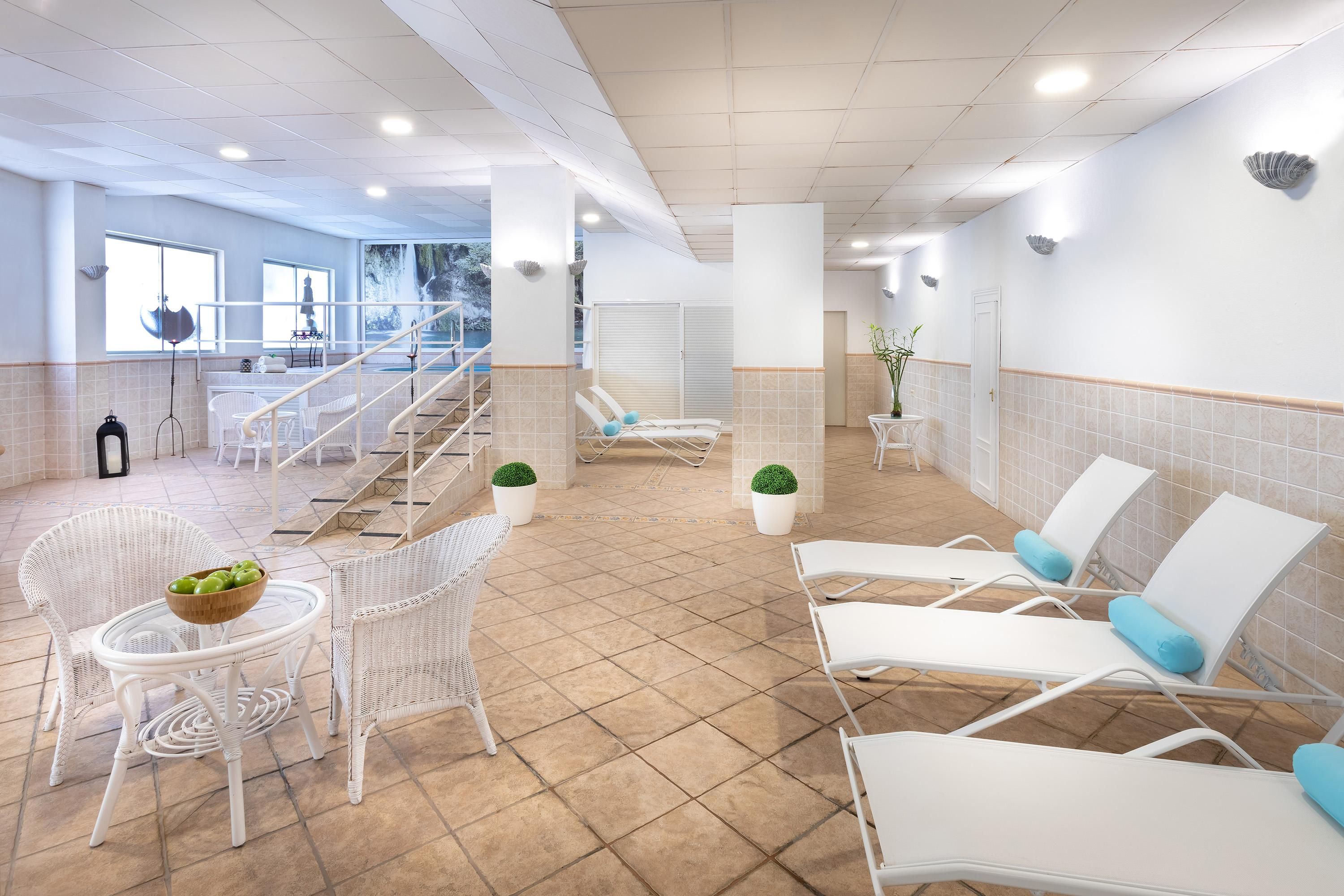 Un espace intérieur spacieux, doté de plusieurs fauteuils confortables et d’une petite table sur laquelle se trouve un saladier rempli de fruits.