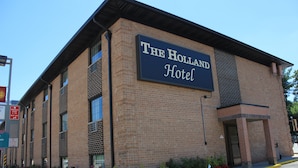 Un edificio de ladrillo con un cartel que dice "The Holland Hotel".