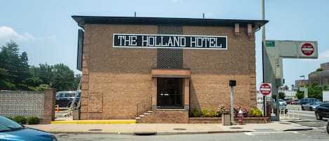 A brick building with a sign reading "The Holland Hotel."