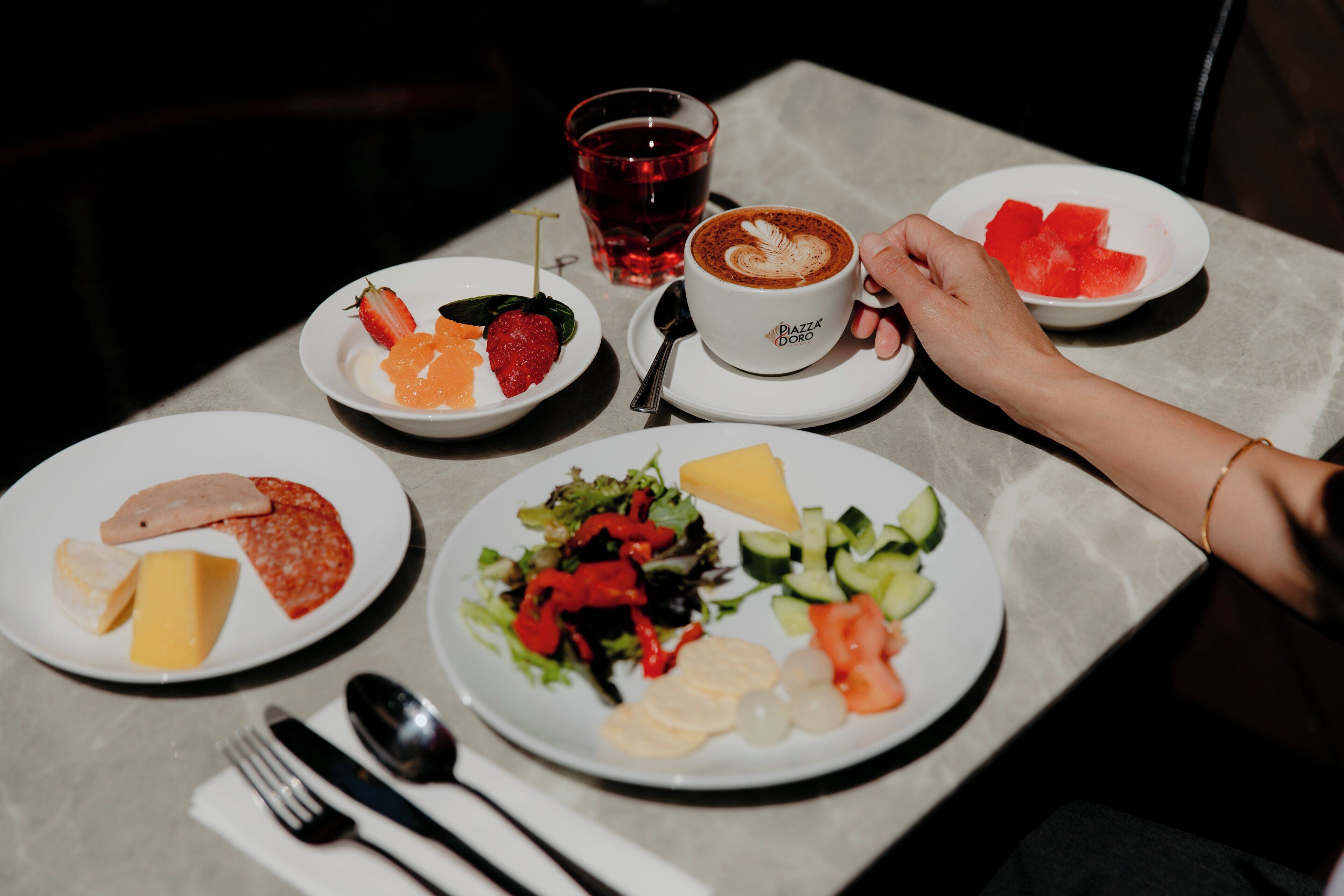 A table with various food items and a cup of coffee.