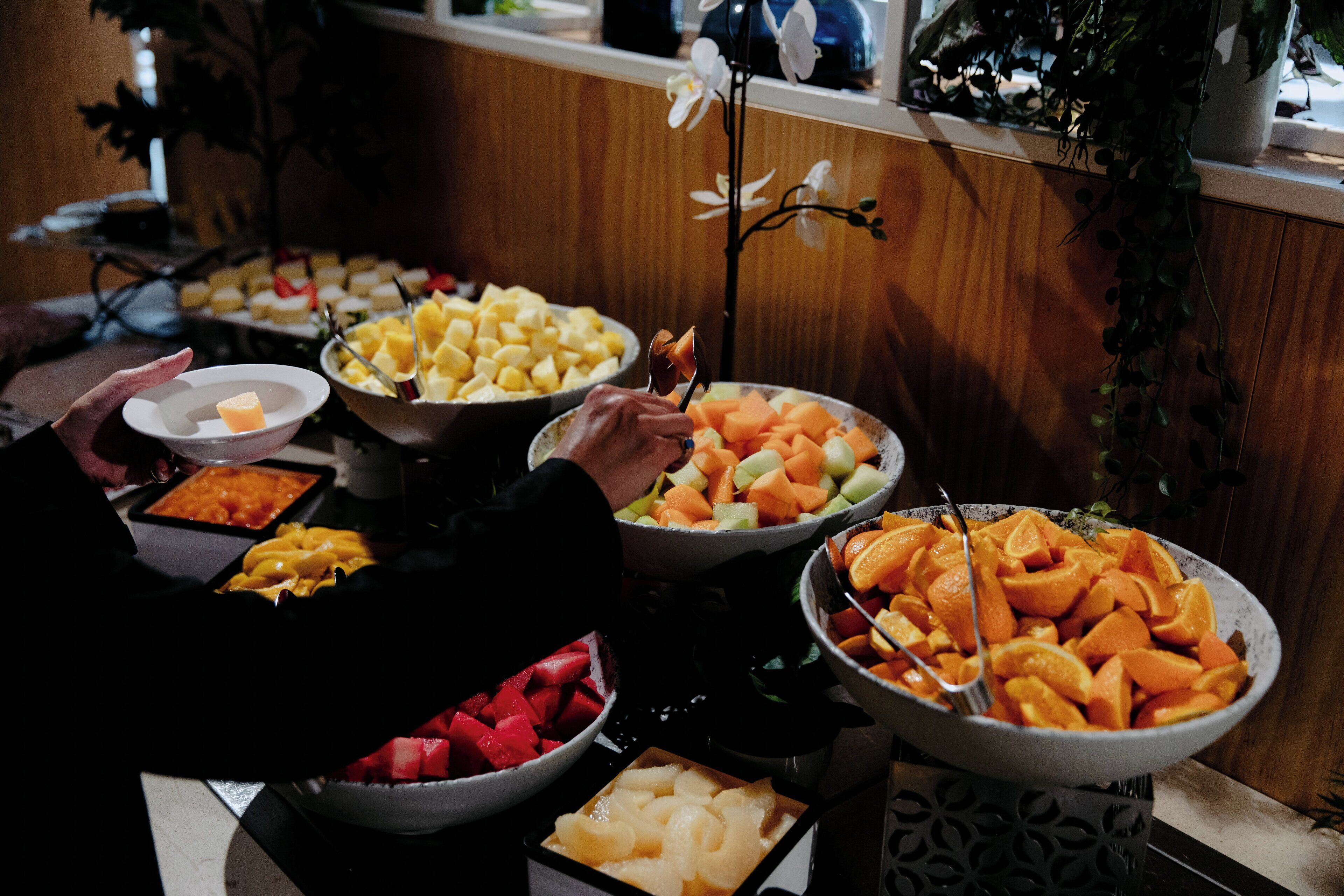 A buffet with various fruits and dishes.