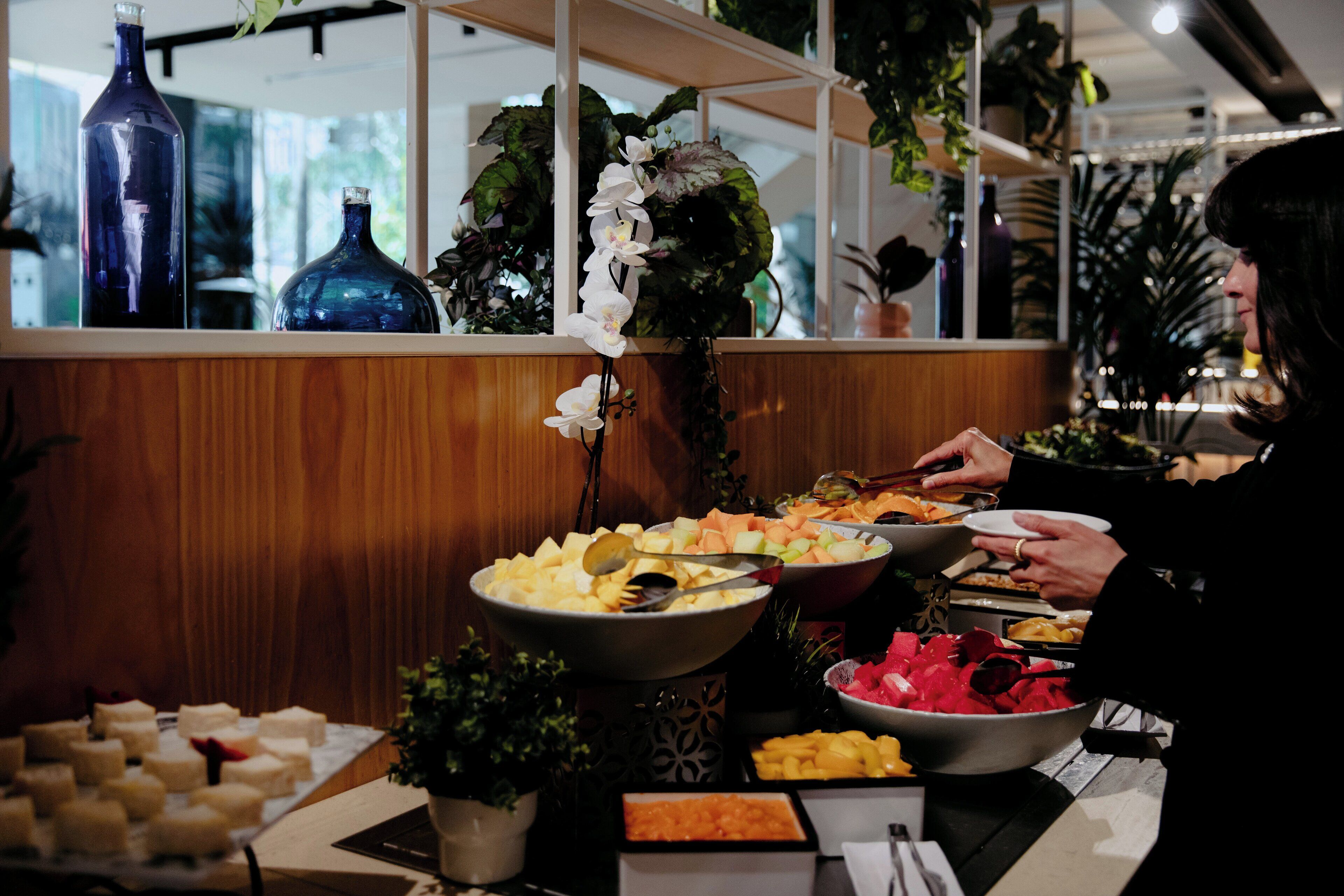 A buffet setup with various food items and decorative elements like vases and plants.