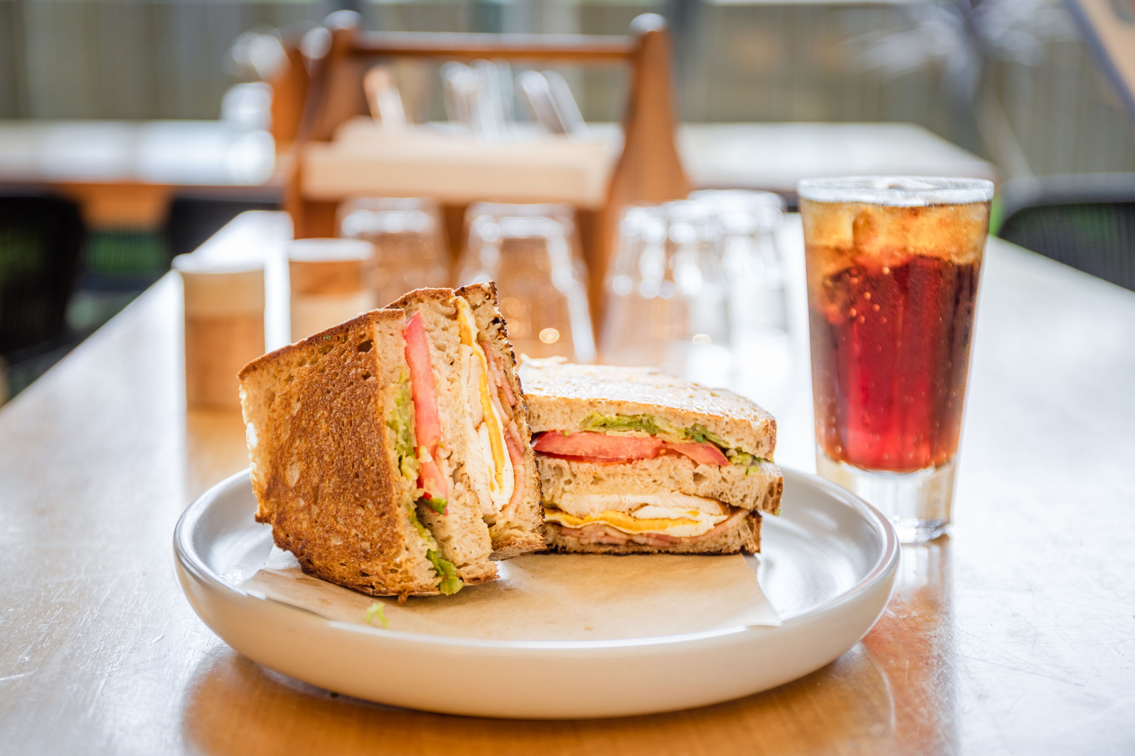 A sandwich on a plate with a glass of iced tea.