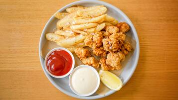 En tallrik med kycklingnuggets, pommes frites, ketchup och majonnäs.