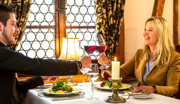 A dining table with a candle, wine glasses, and a salad. - Swiss-Chalet Merlischachen - Romantik Schloss-Hotel am See (Kuessnacht)
