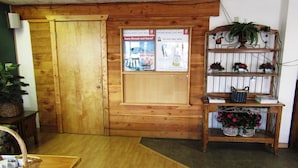 Une porte en bois sur laquelle est affichée une affiche publicitaire pour un coffret cadeau sur le thème des sports d’hiver. Sur la droite, on aperçoit une étagère avec des plantes en pot et des paniers.