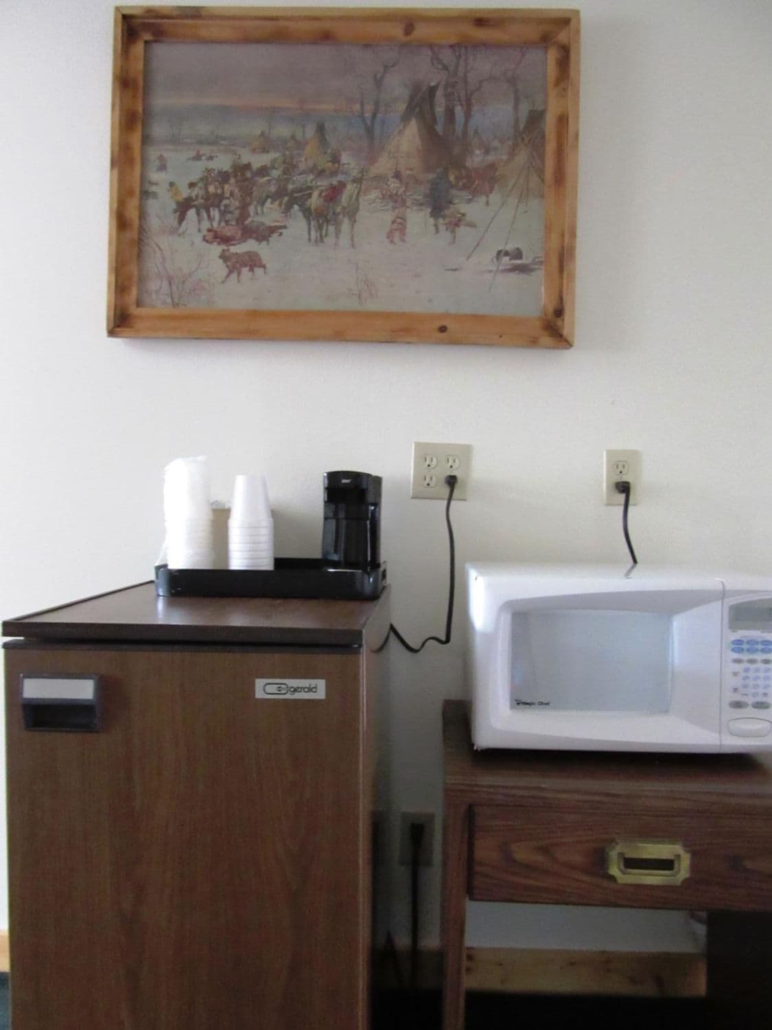 A kitchenette with a coffee maker, a microwave, and a cabinet.