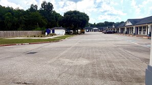 Un parking avec une voie d’accès pour les pompiers, un petit bâtiment et une rangée de chambres d’hôtel.