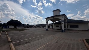 A motel with a large parking lot, a covered entrance, and a row of single-story buildings. - Luxury Inn & Suites Liberty (Liberty)
