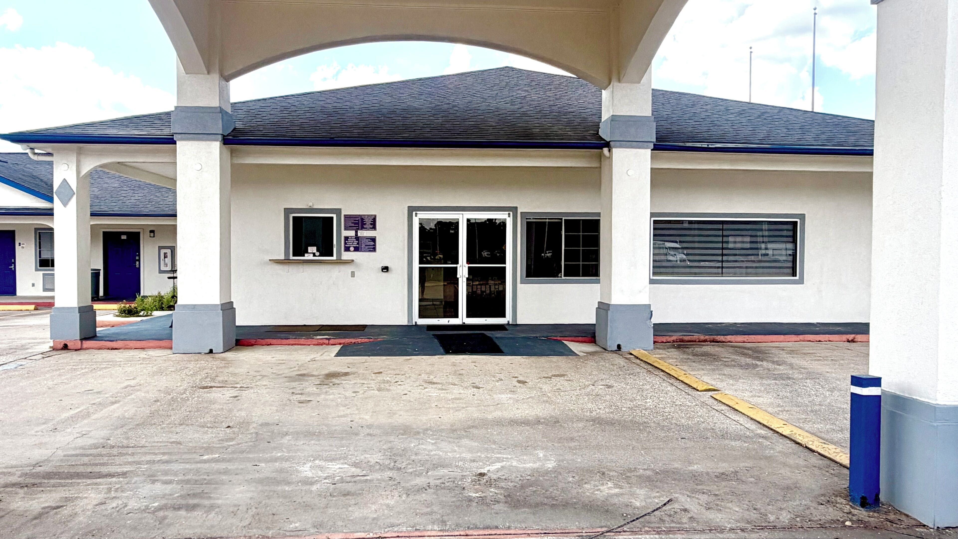 A building with a covered entrance, a door, and a window.