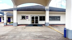 A building with a covered entrance, a door, and a window. - Luxury Inn & Suites Liberty (Liberty)