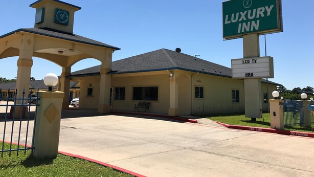 Un hotel de lujo con una entrada destacada, un letrero que indica la disponibilidad de televisores LCD y HBO, y una señalización de acceso para vehículos de emergencia.