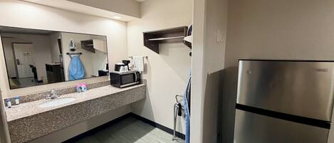 Une salle de bain d’hôtel équipée d’un lavabo, d’un miroir et d’un réfrigérateur de la marque Vissani.