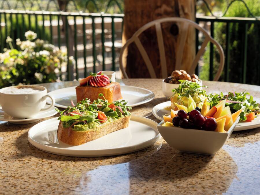 Une table avec des assiettes de nourriture, une tasse et une chaise.