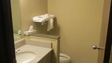 A small bathroom with a sink, toilet, and a mirror.