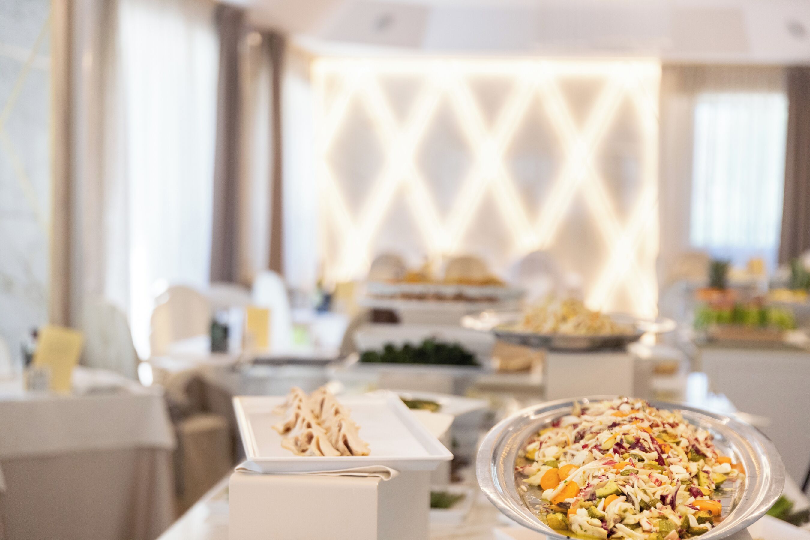 Ein Buffet mit verschiedenen Speisen, darunter eine große Salatschüssel und eine Brotkiste.