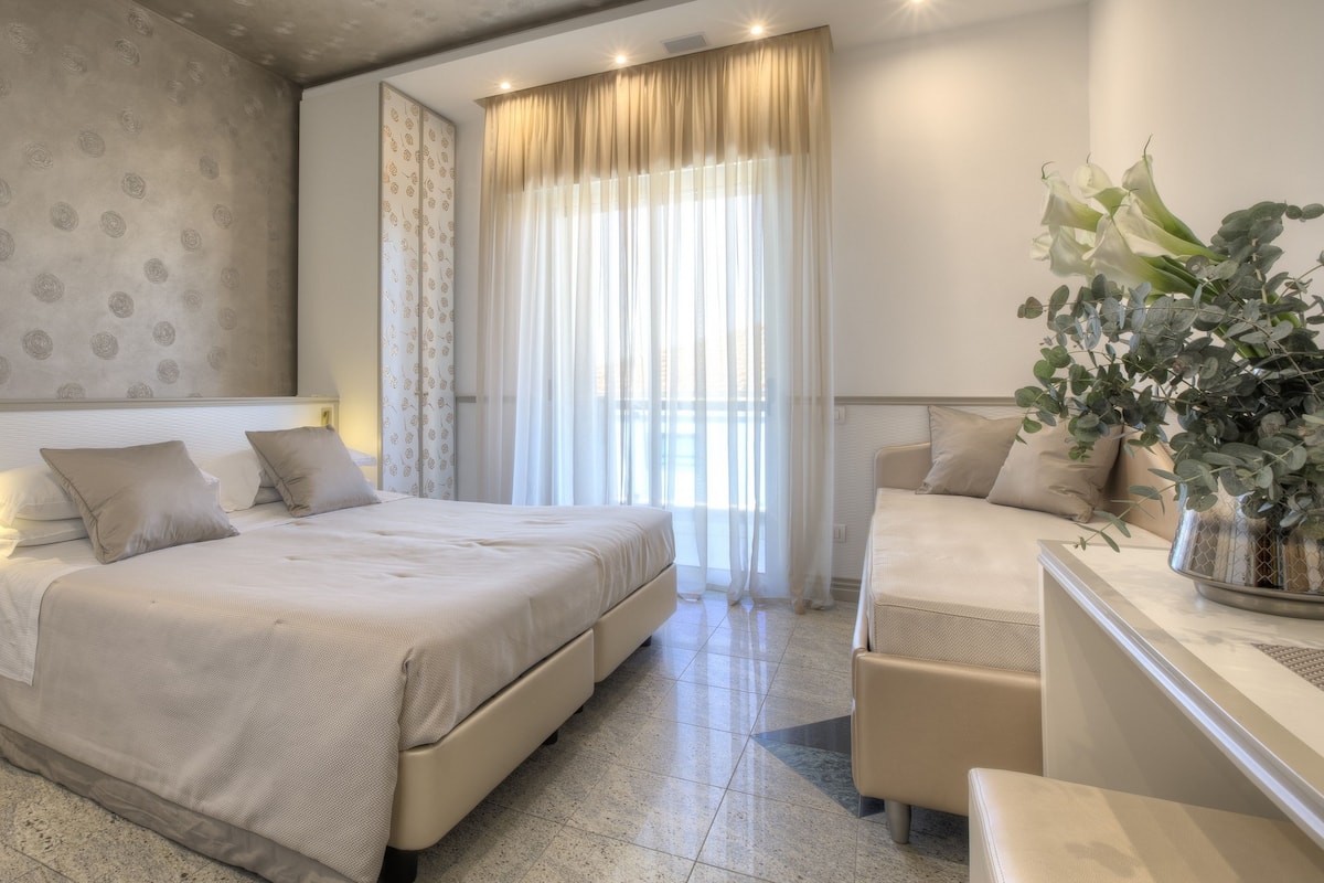 Deluxe Triple Room | Minibar, in-room safe, desk, blackout curtains