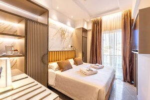 Habitación triple Deluxe | Minibar, caja fuerte, escritorio y cortinas opacas