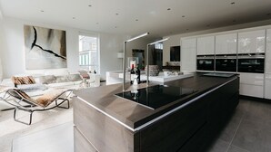 A modern kitchen with a large island, white cabinetry, and a minimalist design. - Fritz am Brunnen (Schwelm)