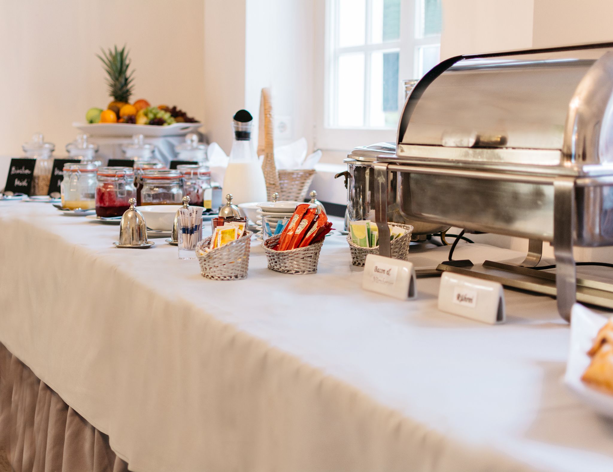 A buffet setup with various food items and condiments.