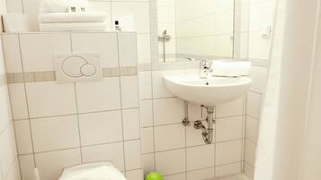 Ein Badezimmer mit Toilette, Waschbecken und Spiegel.