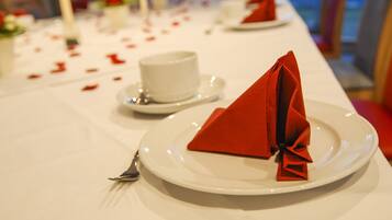 A table set with white plates, red napkins, and a white cup.