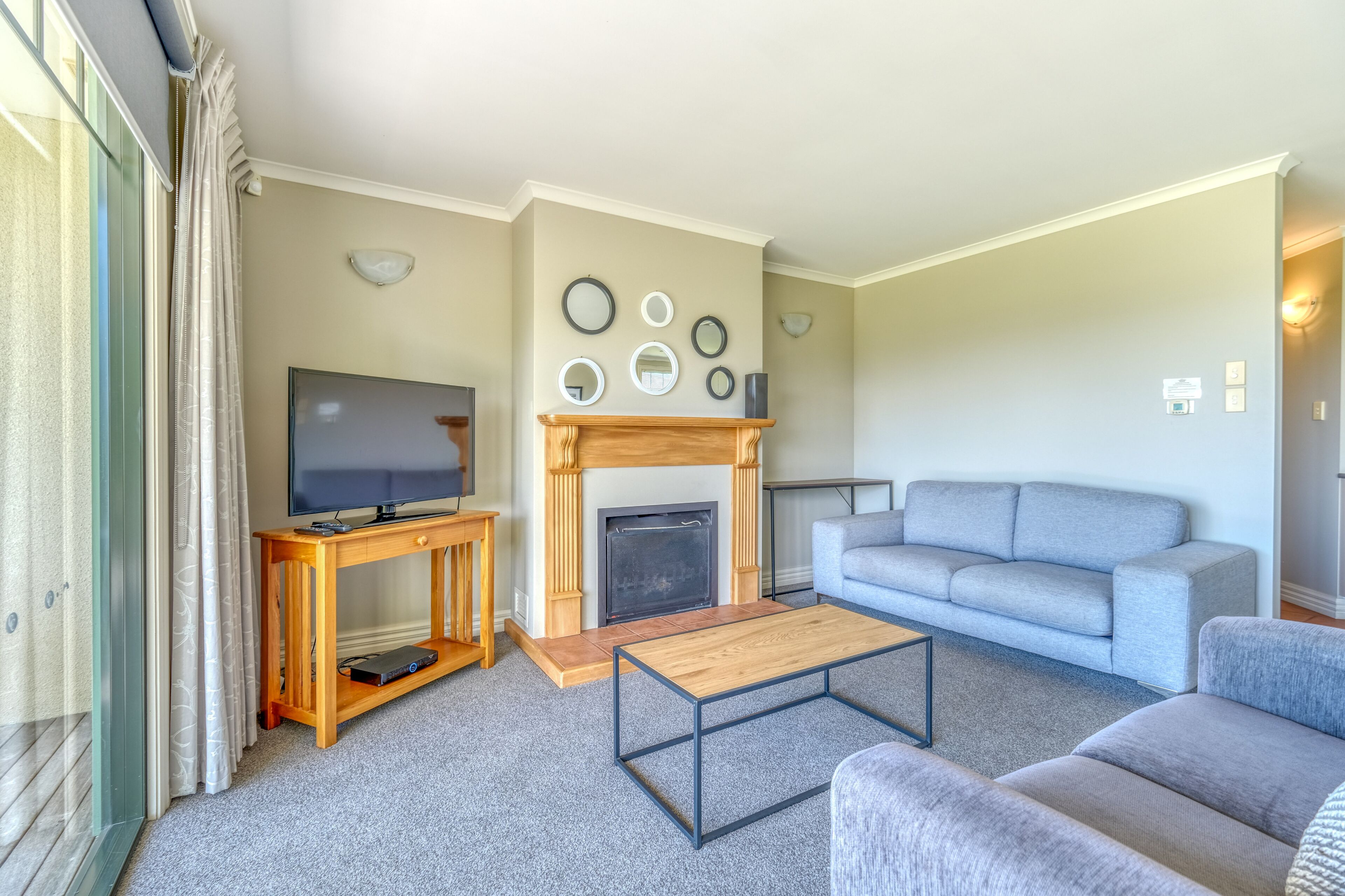A living room with a fireplace, a television, a sofa, and a coffee table.