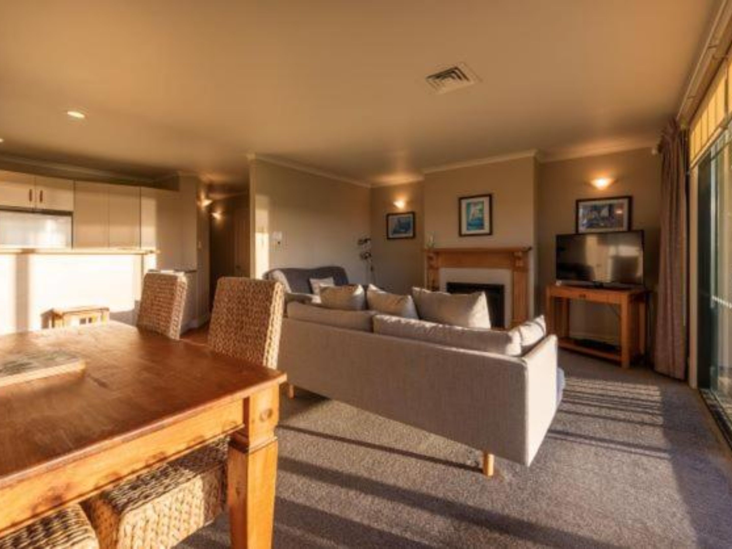 A cozy living room with a fireplace, a sofa, a TV, and a dining table.