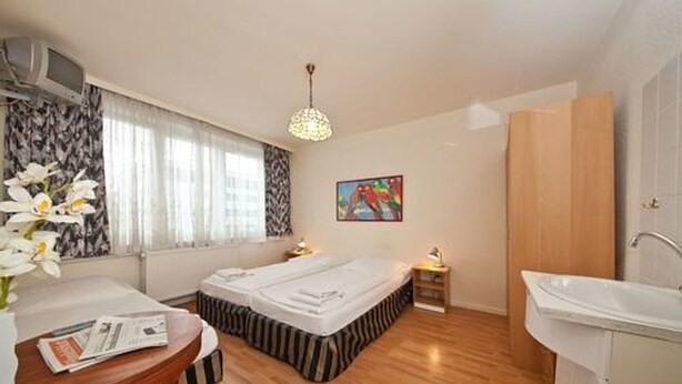 Une chambre d’hôtel avec un lit, une table de chevet, une lampe et un tableau au mur.
