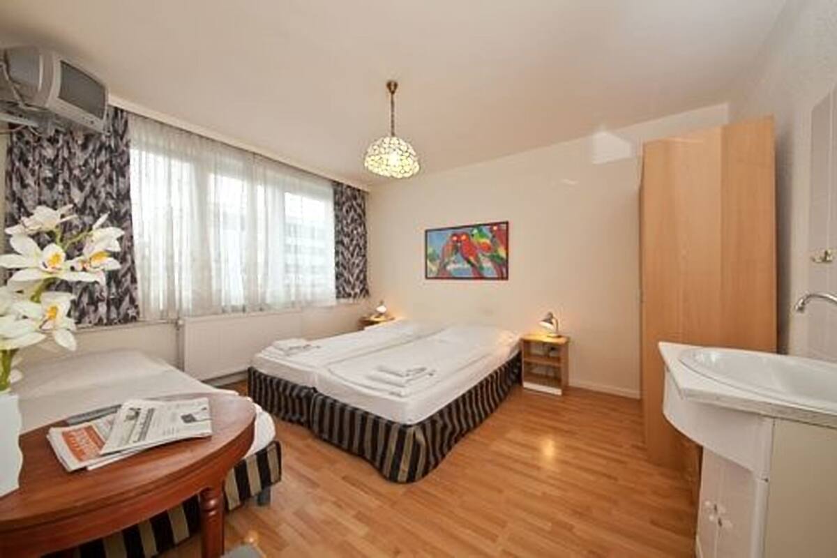Une chambre d’hôtel avec un lit, une table de chevet, une lampe et un tableau au mur.