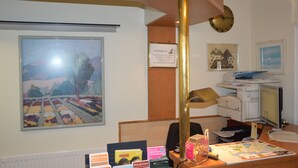 Une chambre d’hôtel équipée d’un bureau, d’un ordinateur, d’une imprimante et d’un tableau encadré accroché au mur.