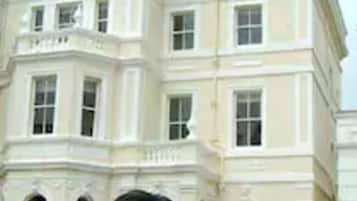 A large, white, classical-style building with multiple windows and a prominent entrance.
