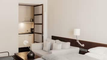 Ein Hotelzimmer mit Bett, Nachttisch, Lampe und Blick ins Badezimmer.