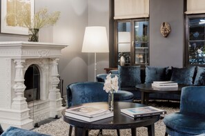 Cozy living room with a fireplace, comfortable seating, and a view of the outdoors.