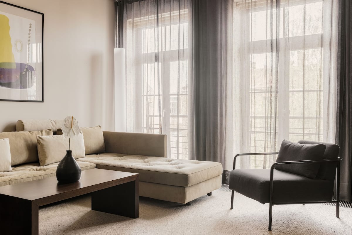 Una sala de estar moderna con sofá, sillón y mesa de centro.