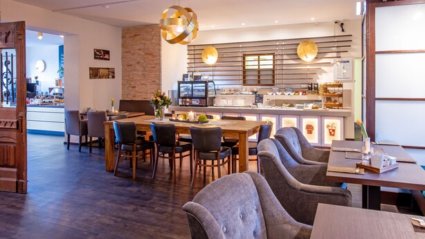 Un restaurant moderne doté d’un bar, de meubles en bois et d’un mur décoratif en briques.