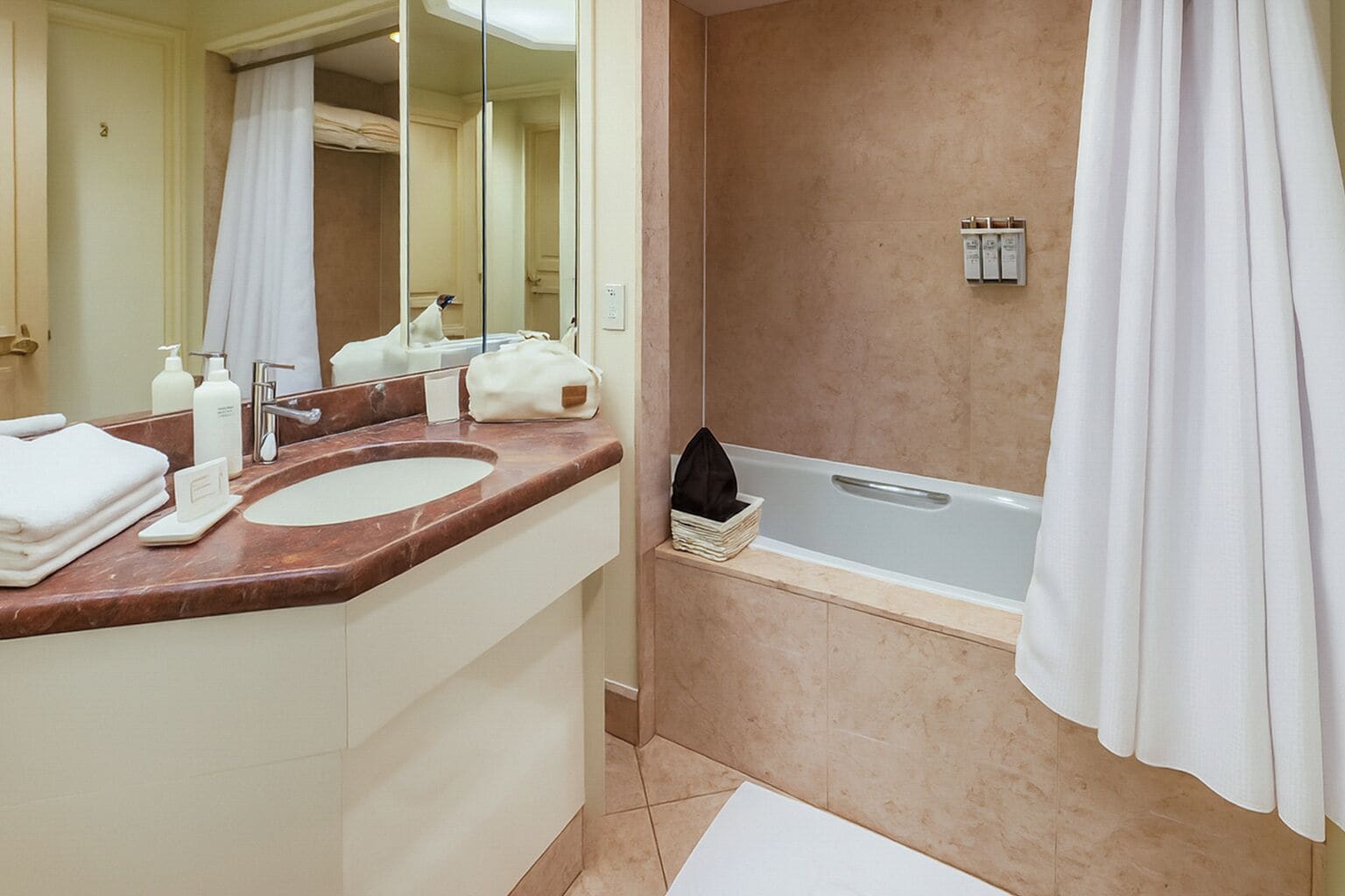 A bathroom with a double sink, a mirror, a towel rack, a shower curtain, and a bathtub.