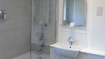 Une salle de bain moderne avec une douche à parois de verre, un lavabo blanc et des toilettes.